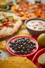 Image showing Close up on black beans with various freshly made Mexican foods assortment
