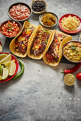 Image showing Tasty Mexican meat tacos served with various vegetables and salsa