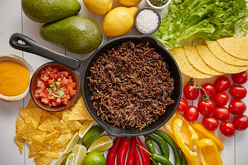 Image showing Ingredients for Chili con carne in frying iron pan on white wooden table