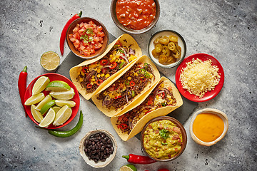 Image showing Tasty Mexican meat tacos served with various vegetables and salsa