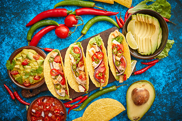 Image showing Mexican taco with chicken meat, jalapeno, fresh vegetables served with guacamole