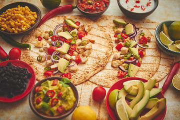 Image showing Freshly made healthy corn tortillas with grilled chicken fillet, big avocado slices