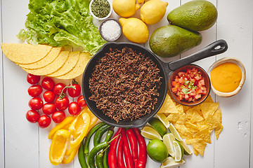 Image showing Ingredients for Chili con carne in frying iron pan on white wooden table