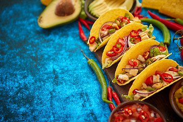 Image showing Mexican taco with chicken meat, jalapeno, fresh vegetables served with guacamole