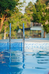 Image showing An open swimming pool with a shiny railing and a sunny background