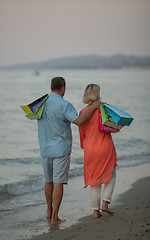 Image showing A middle aged couple walking down the sea coast barefoot