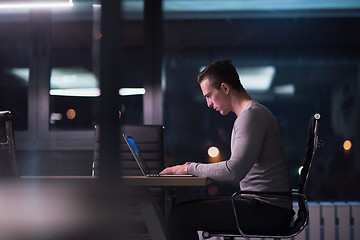 Image showing man working on laptop in dark office