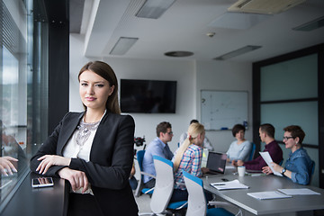 Image showing Elegant Woman Using Mobile Phone by window in office building