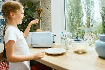 Image showing Beautiful girl in her kitchen in the morning preparing breakfast