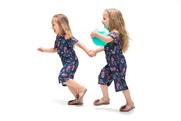 Image showing Smiling cute toddler girls three years running over white background