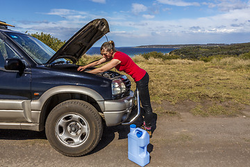 Image showing Woman fixing her broken down car 4wd