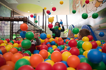 Image showing Young mom with her kids in a children\'s playroom