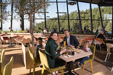 Image showing Young parents enjoying lunch time with their children