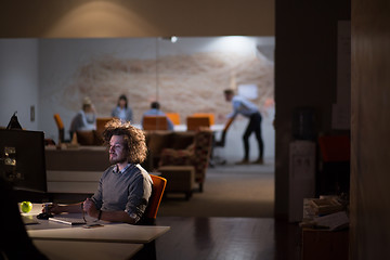 Image showing man working on computer in dark office