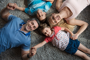 Image showing happy family lying on the floor