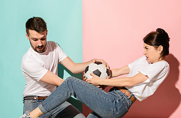 Image showing The unhappy and angry fans on colored blue and pink background.