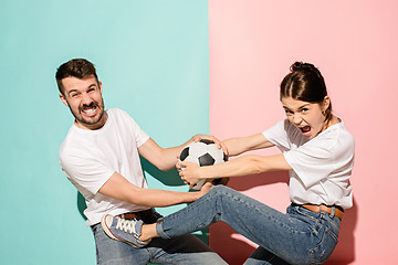 Image showing The unhappy and angry fans on colored blue and pink background.