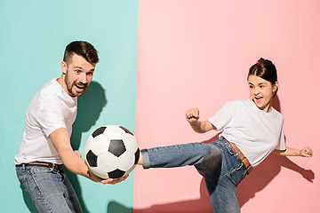 Image showing The young football fans plaing with ball on blue and pink trendy colors.