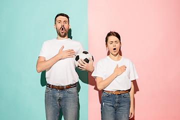 Image showing The young fans singing national anthem on blue and pink trendy colors.