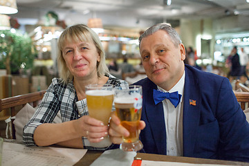 Image showing A portrait of a smiling middle aged couple with glasses of beer