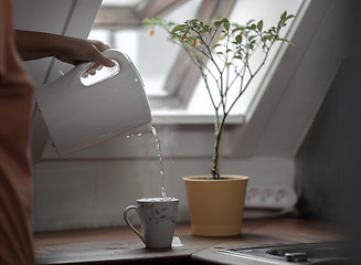 Image showing Water flowing from the electric kettle to the cup