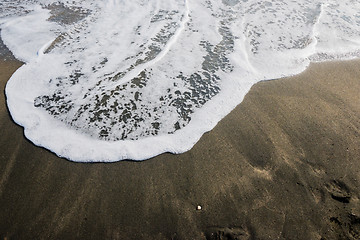 Image showing Beautiful soft wave on black sand at the sea