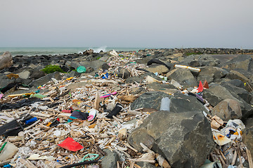 Image showing Spilled garbage on the beach near the big city. Empty used dirty plastic bottles and other garbage. Environmental pollution. Ecological problem.