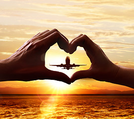 Image showing Hands of lovers and taking-off plane