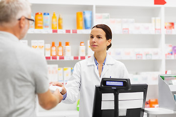 Image showing apothecary selling drug to senior man at pharmacy