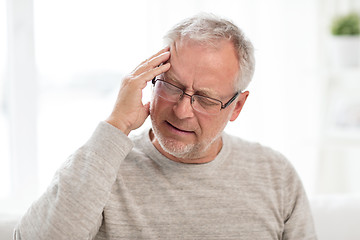 Image showing senior man suffering from headache at home