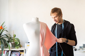 Image showing fashion designer with dummy making dress at studio