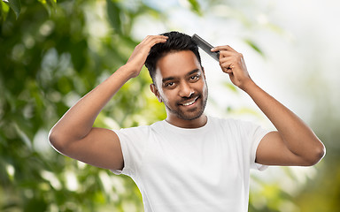 Image showing indian man brushing hair over natural background