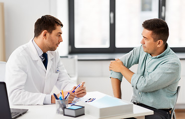 Image showing patient showing sore arm to doctor at hospital