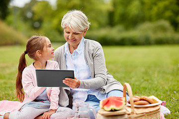 Image showing grandmother and granddaughter with tablet at park