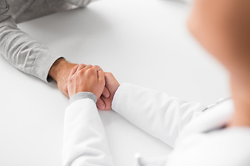 Image showing close up of doctor holding senior patient hand