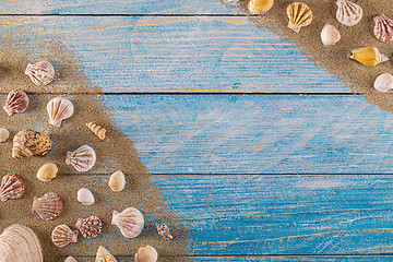 Image showing Summer time concept with sea shells on a blue wooden background 