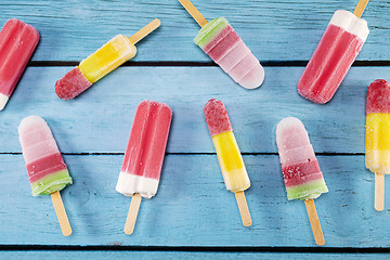 Image showing Ice cream stick placed on a blue vintage wooden 