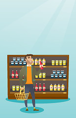 Image showing Man holding shopping basket and bottle of sauce.