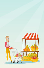 Image showing Young caucasian woman pushing a supermarket cart.