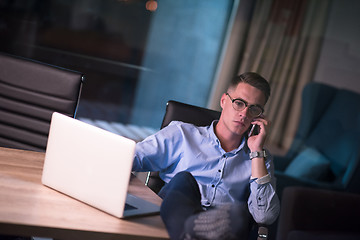 Image showing businessman using mobile phone in dark office