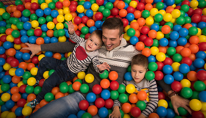 Image showing Young dad with kids in a children\'s playroom