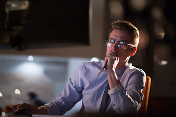 Image showing man working on computer in dark office