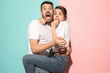 Image showing Portrait of the scared man and woman on pink and blue