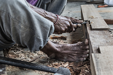 Image showing Close up of warn hands of carpenter working in traditional manual carpentry shop in a third world country.