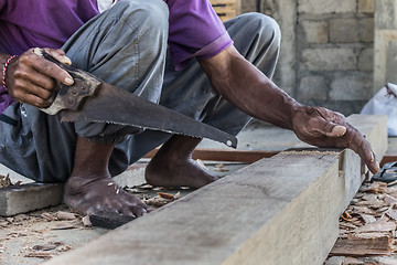 Image showing Close up of warn hands of carpenter working in traditional manual carpentry shop in a third world country.