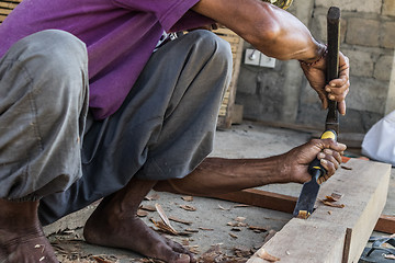 Image showing Close up of warn hands of carpenter working in traditional manual carpentry shop in a third world country.