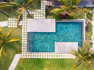 Image showing Aerial view of luxury hotel resort with swimming pool with stair and wooden deck surrounded by palm trees.