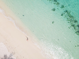 Image showing Aerial shot of woman enjoying the picture perfect white tropica beach on Mauritius island.