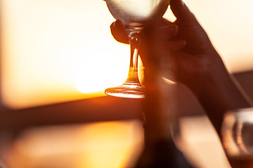 Image showing Wineglass in female hand against the sunset