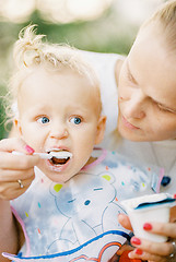 Image showing Feeding a baby girl